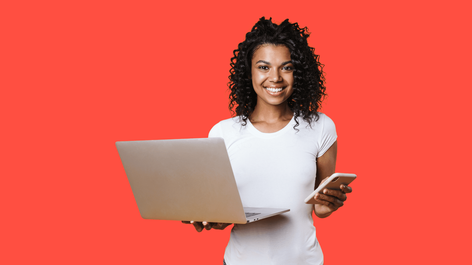 Woman holding a phone and laptop to illustrate the success of a good SEO strategy